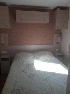 a bedroom with a bed with a white comforter at danseuse 33 in Parentis-en-Born +9 photos