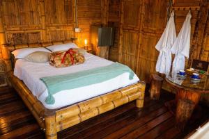 a bed in a wooden room with a table at Rinconcito Guzmán in Pereira