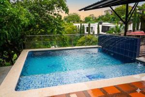 a swimming pool with blue water in a backyard at Rinconcito Guzmán in Pereira