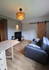 a living room with a couch and a table at Zacisze Wilcza in Zarzecze +6 photos