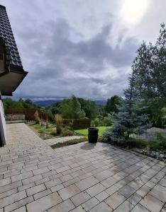 a patio in a yard with a fence and trees at Zacisze Wilcza in Zarzecze