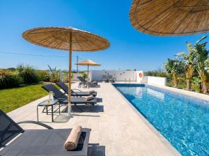 a swimming pool with chairs and umbrellas next to a pool at Lilu Villa 1 with Private Pool and Seaview in Tigaki