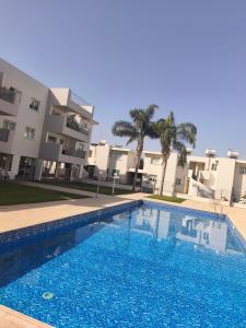 a swimming pool in front of a building at Michelle Mediterranean Suites in Meneou