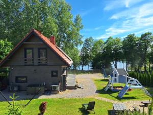 a small house with a playground and a slide at Mazurska Widokówka in Węgorzewo