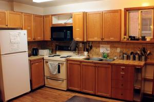 a kitchen with wooden cabinets and a white refrigerator at Ottawa Backpackers Inn in Ottawa