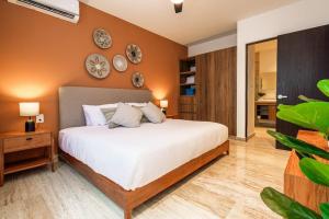 a bedroom with a large bed with clocks on the wall at Ceiba 25 by Andiani Travel in Playa del Carmen