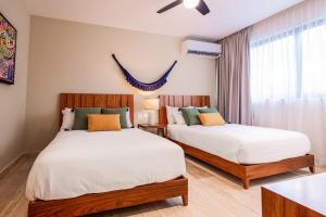 a bedroom with two beds and a window at Ceiba 25 by Andiani Travel in Playa del Carmen
