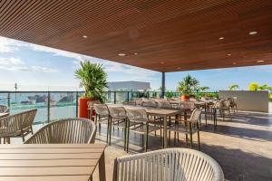 a restaurant with tables and chairs on a balcony at Ceiba 25 by Andiani Travel in Playa del Carmen