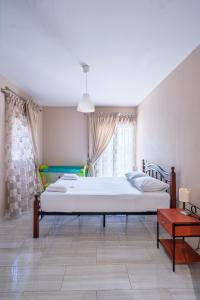 a bedroom with a large white bed and a table at La Sirenetta Residence in Syvota +63 photos