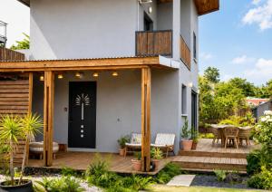 a house with a deck with a black door at Villa des trois singes in Saint-Pierre
