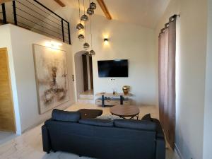 a living room with a blue couch and a table at L'Écrin de Nature Panoramic View & Prestige in Saint-Marcel-lès-Annonay
