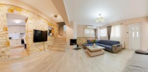 a living room with a blue couch and a stone wall at La Sirenetta Residence in Syvota