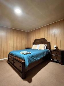 a bedroom with a bed with a blue comforter at La Casona - Refugio Austral in Punta Arenas