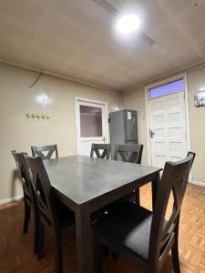 a dining room with a table and chairs and a refrigerator at La Casona - Refugio Austral in Punta Arenas