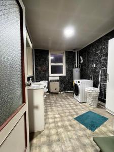 a bathroom with a sink and a washing machine at La Casona - Refugio Austral in Punta Arenas