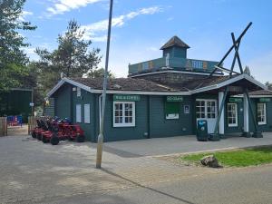 a small green building with a tractor in front of it at LuLu's Lodge, Billing Aquadrome in Northampton
