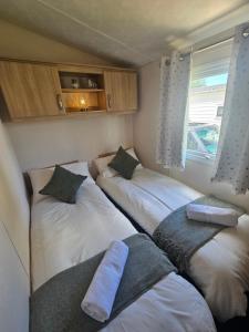 a room with three beds and a window at LuLu's Lodge, Billing Aquadrome in Northampton