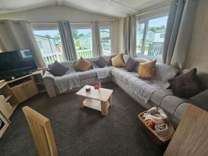 a living room with a couch and a tv at LuLu's Lodge, Billing Aquadrome in Northampton