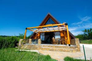 a log cabin with a thatched roof and a patio at Kosmaj Escape in Koraćica