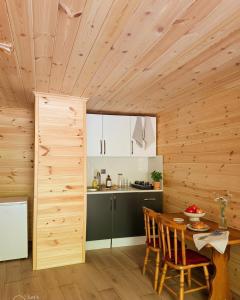 a kitchen with a wooden ceiling and a table with chairs at Ayder River Suite by Karadeniz in Ardeşen