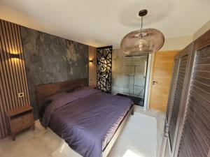 a bedroom with a purple bed and a window at L'Écrin de Nature Panoramic View & Prestige in Saint-Marcel-lès-Annonay