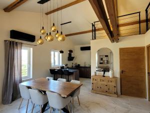 a kitchen and dining room with a wooden table and chairs at L'Écrin de Nature Panoramic View & Prestige in Saint-Marcel-lès-Annonay