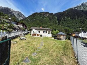 a yard with a fence in front of a mountain at Casa del Sole in Dangio