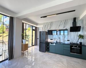 a kitchen with blue cabinets and a marble wall at Modern Villa - infinity pool & Panoramic Sea View in Kvariati