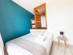 a bedroom with a white bed with a mirror at Villa des trois singes in Saint-Pierre