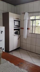 a kitchen with a microwave oven and a window at Recanto Vieira in Lages +4 photos