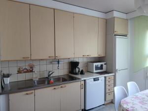 a kitchen with white cabinets and a sink and a microwave at Kolmio Väinöläntie 6 in Lieksa