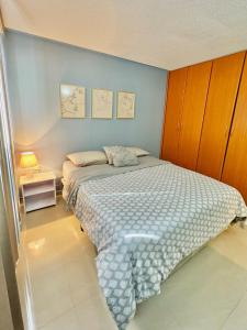 a small bedroom with a bed and a night stand at Genoves Suite muy centrico in Porlamar +18 photos