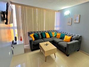 a living room with a couch with colorful pillows at Genoves Suite muy centrico in Porlamar