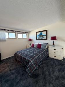a bedroom with a bed and two dressers and two lamps at Coastal Comfort in Oxnard