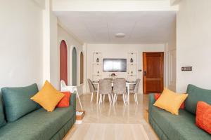 a living room with two green couches and a table at Eden Appartement avec Piscine Et Salle de Sport in El Jadida