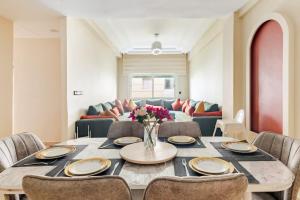 a dining room with a table and chairs at Eden Appartement avec Piscine Et Salle de Sport in El Jadida