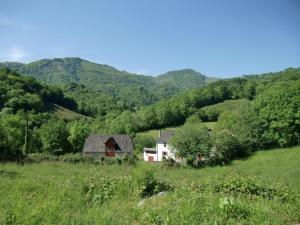 a house in a field with mountains in the background at Iagonia in Lacarry-Arhan-Charritte-de-Haut