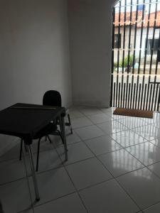 a table and a chair in a room with a window at Wesley in São Luís