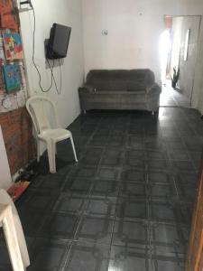 a room with a bed and a chair and a tiled floor at Wesley in São Luís