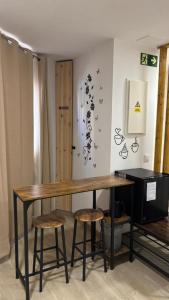 a wooden table with two stools in a room at Al Mar pensión in Alicante