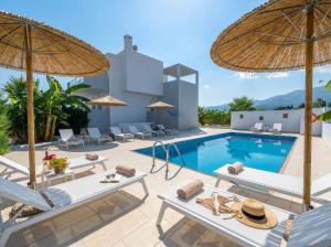 a villa with a swimming pool with chairs and umbrellas at Lilu Villa 2 with Private Pool and Seaview in Tigaki