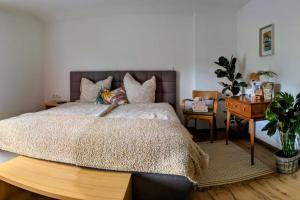 a bedroom with a large bed and a desk with a chair at Mitzi's Zauberblick in Landeck