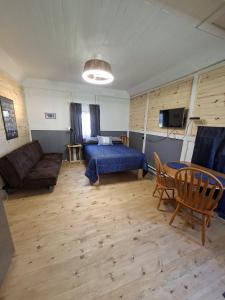 a bedroom with a bed and a couch and a table at Cabines Boréales et Maison de chambres in Rimouski