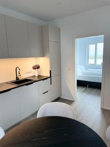 a kitchen with white cabinets and a table and chairs at New Modern Two bedroom Apartment in Hveragerði
