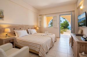 a hotel room with a bed and a television at Alonissos Beach Bungalows And Suites Hotel in Alonnisos