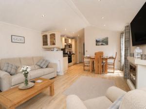 a living room with a couch and a table at Tiggywinkle Beck Lodge in Windermere