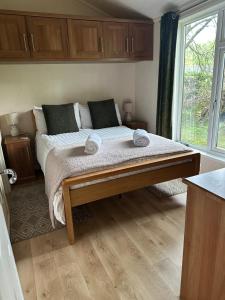 a bedroom with a bed with two towels on it at Tiggywinkle Beck Lodge in Windermere +11 photos