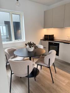 a kitchen and dining room with a table and chairs at New Modern Two bedroom Apartment in Hveragerði