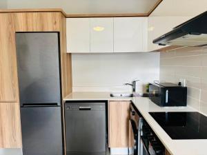 a kitchen with a stainless steel refrigerator and cabinets at Cozy&Pristine The Blyde in Pretoria