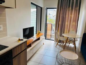 a kitchen and living room with a tv and a table at Cozy&Pristine The Blyde in Pretoria